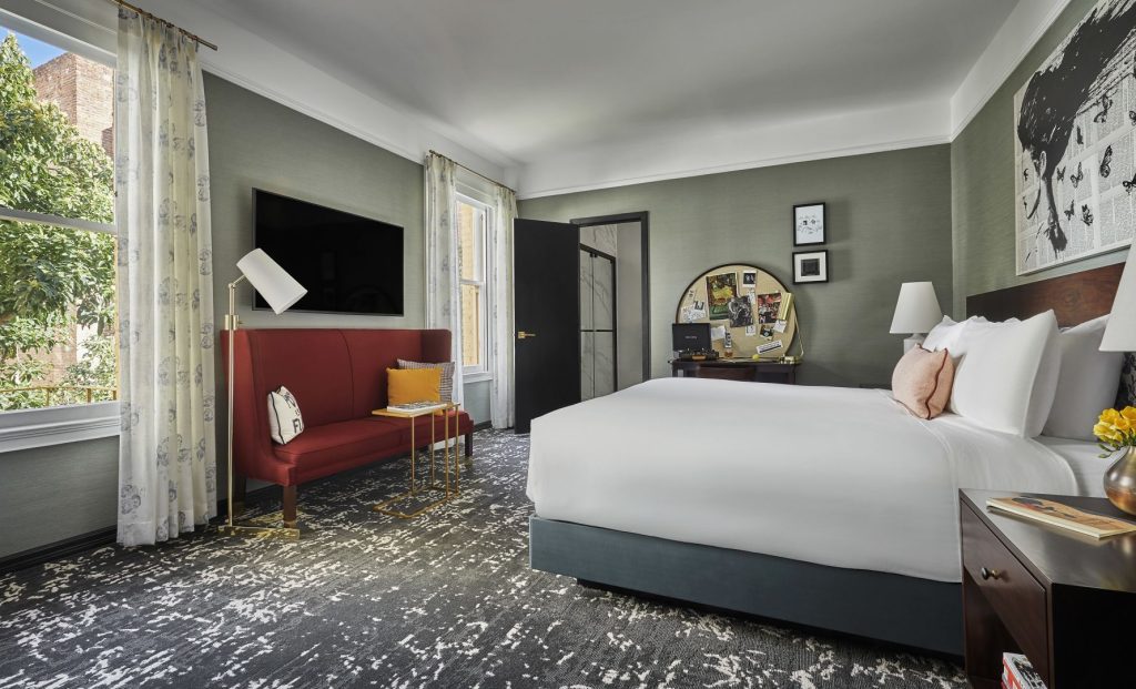 Hotel Emblem San Francisco room with king bed, reading nook sofa, and literary-inspired décor.
