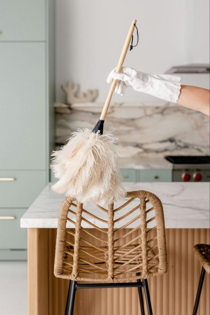Housekeeper holding feather duster in hotel room