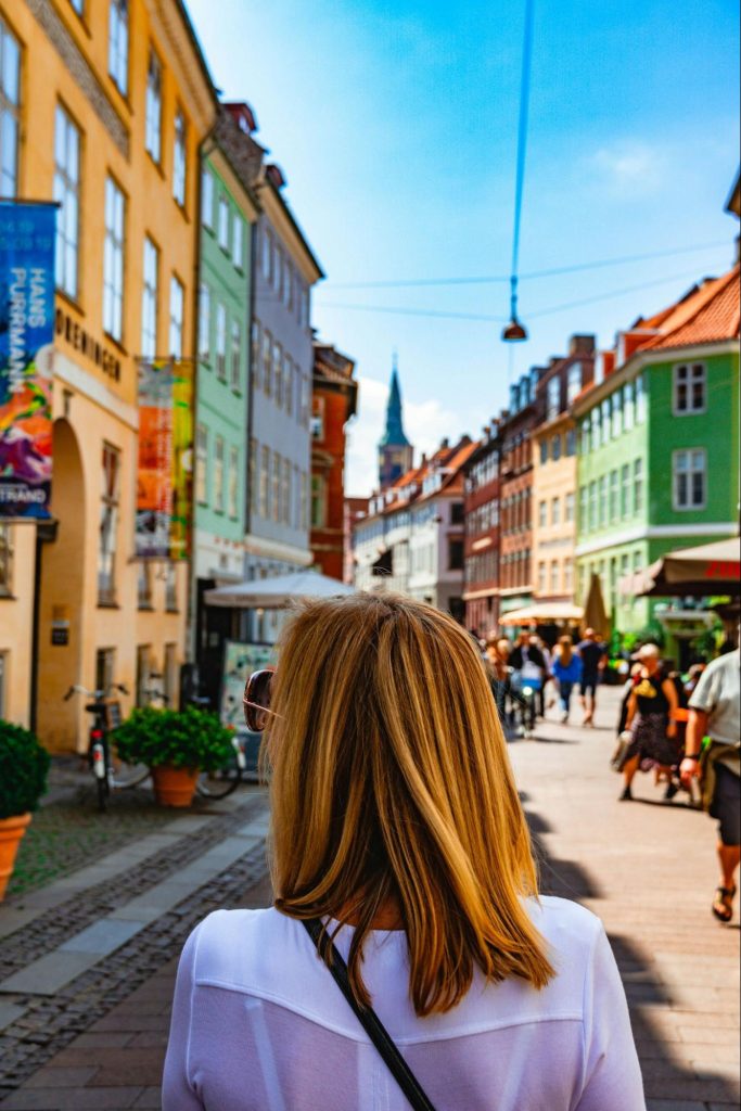 Woman walking along colorful street in Copenhagen