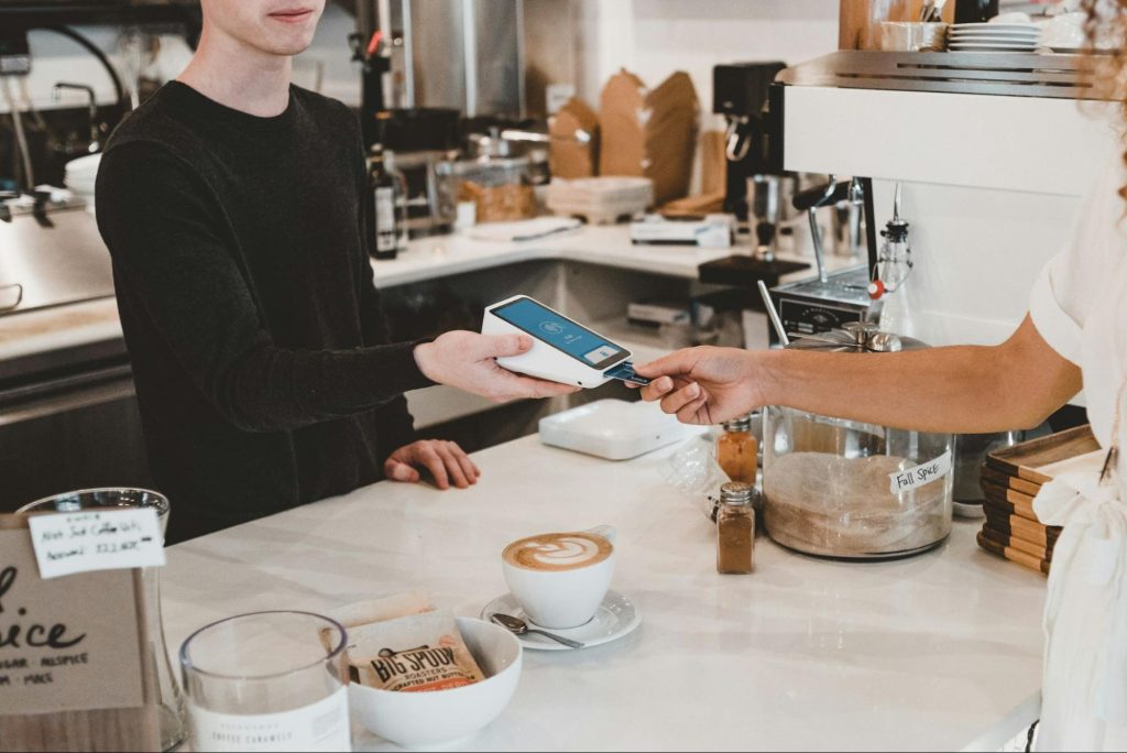 Customer paying by card at café counter