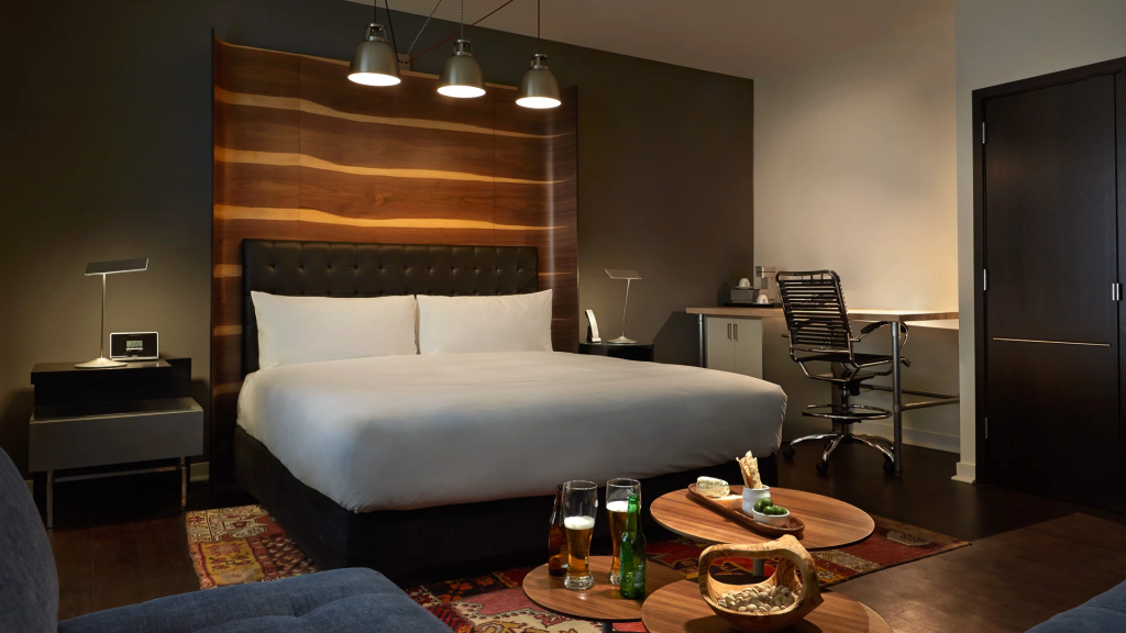 Hotel Zetta San Francisco modern guest room with wood accent wall, king bed, and work desk.