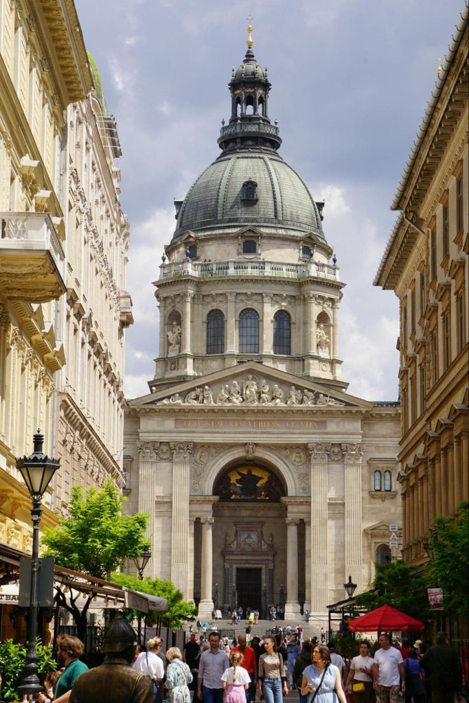 Historic church with massive dome and crowded city street.