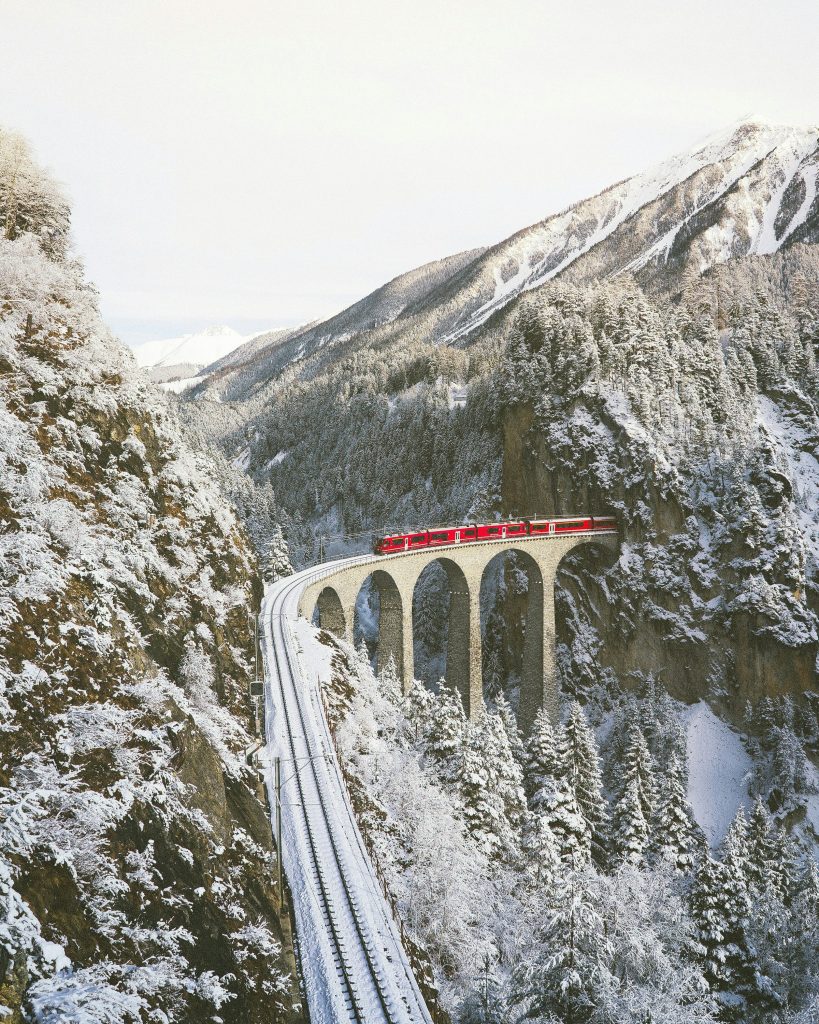 Swiss red train on snowy viaduct
