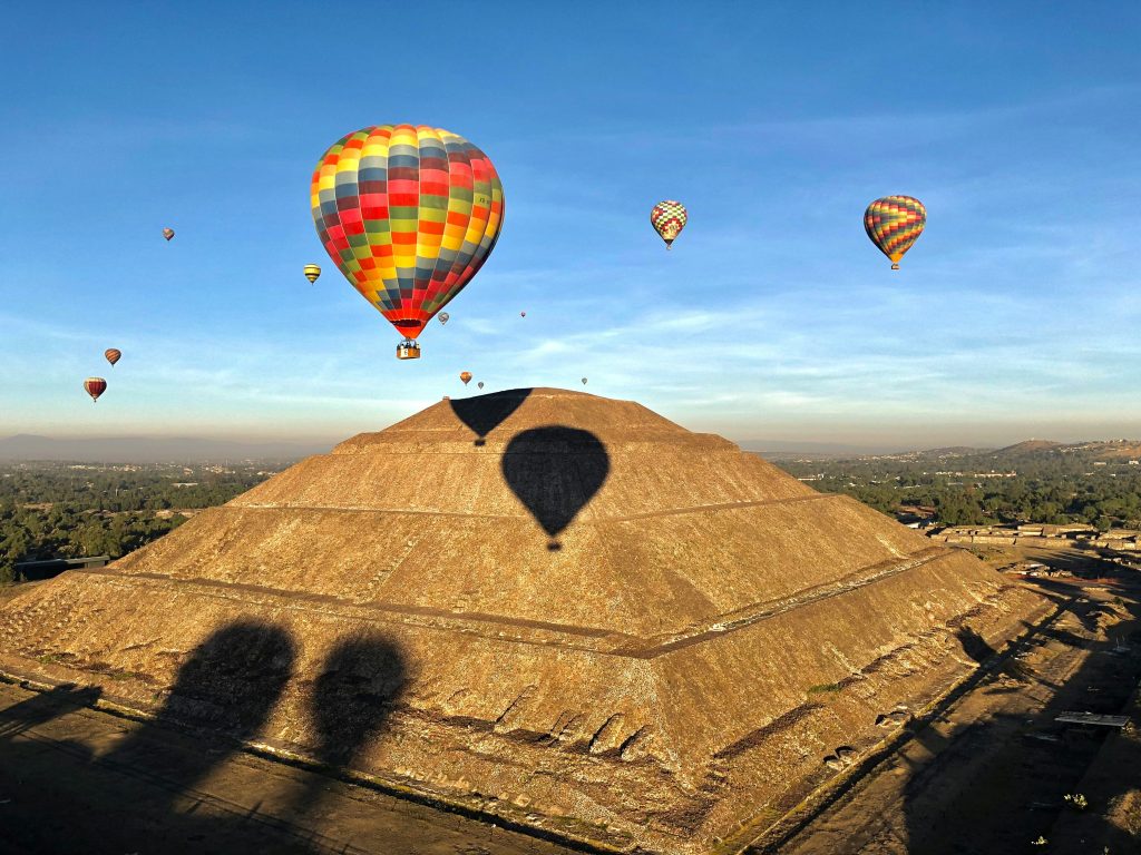 Hot air balloons floating above the Pyramid of the Sun in Teotihuacan.